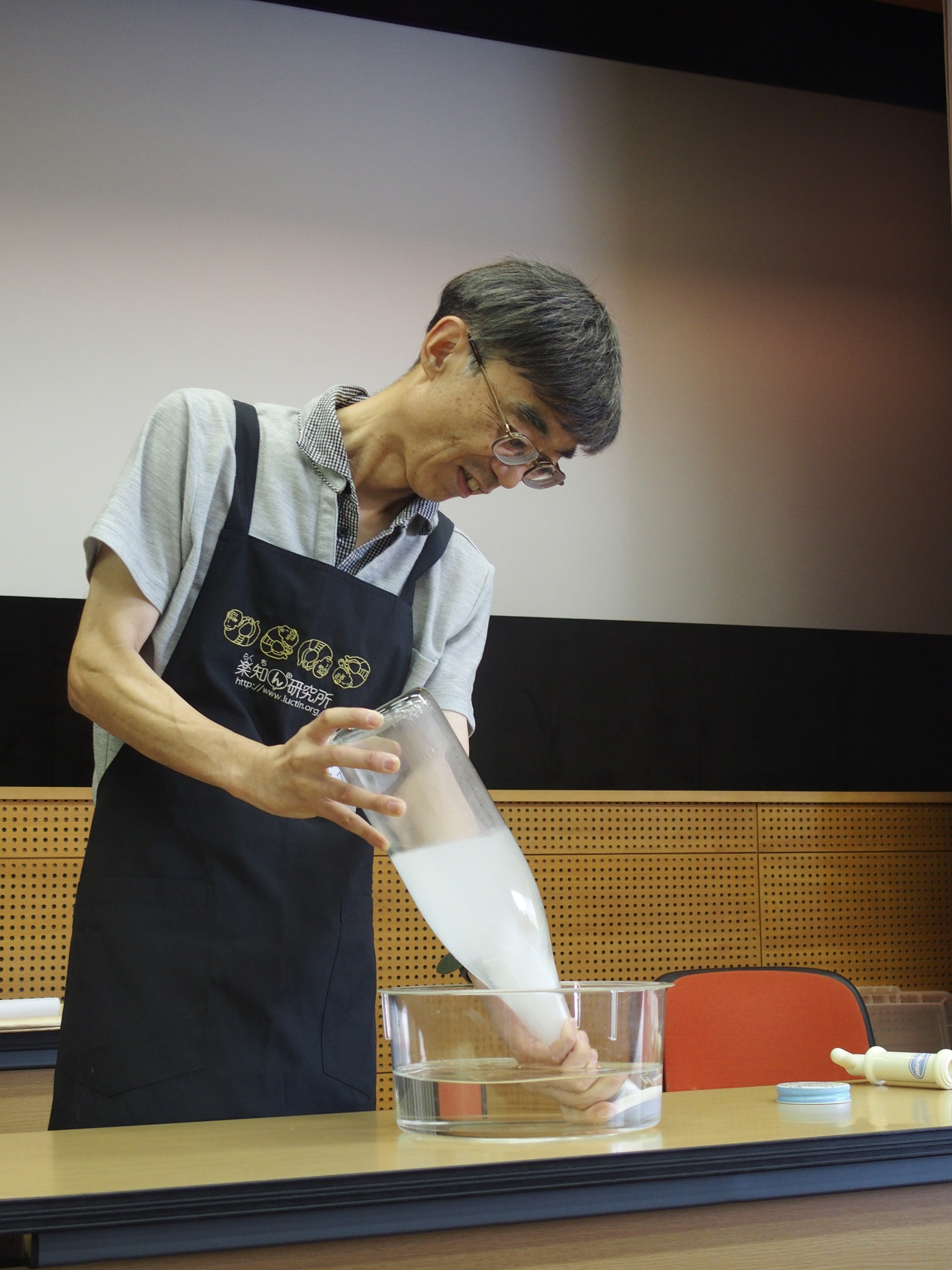 田部井先生が真空のビンに水を入れている姿